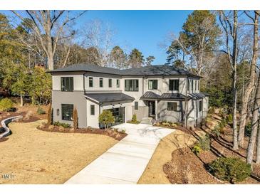 Two-story modern home with gray siding, large windows, and a long driveway at 2104 Manuel St, Raleigh, NC 27612