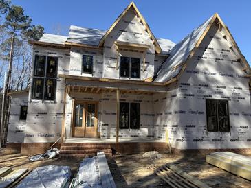 Craftsman style home under construction, featuring a brick facade and multi-pane windows at 1317 Old Lystra Rd, Chapel Hill, NC 27517