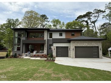 Stunning modern two-story home featuring a two-car garage and a beautifully landscaped front yard at 4123 Rockingham Dr, Raleigh, NC 27609