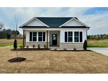 Charming single-story home featuring black shutters, brick accents, and a welcoming front porch at 189 Waterwheel Dr, Selma, NC 27576