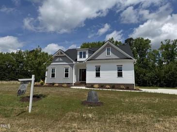 Charming two-story home with white and grey siding and a well-manicured lawn at 35 Uptown Rd, Zebulon, NC 27597