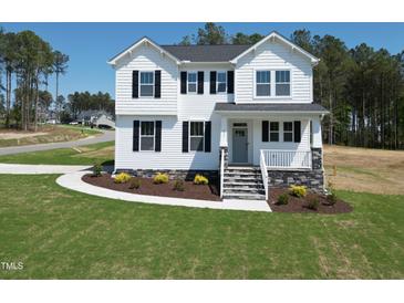 Charming two-story home featuring white siding, black shutters and a well-manicured lawn on a sunny day at 439 Duncan Creek Rd # 140, Lillington, NC 27546
