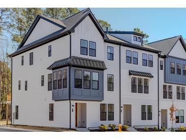 Charming three-story townhome featuring Hardie siding, black window accents, and an inviting entryway at 6408 Tanner Oak Ln, Raleigh, NC 27613