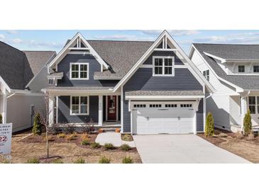 Charming home with navy siding, white trim, two-car garage, and landscaped front yard at 416 S Cross St, Youngsville, NC 27596