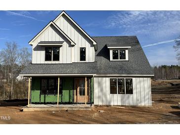 New two-story home featuring light grey siding, a dark grey roof, and a wood front door under a sunny blue sky at 103 Slocum Dr, Wendell, NC 27591