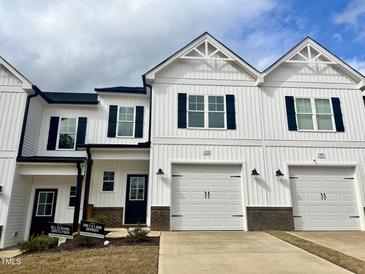 Charming townhomes with white siding, black shutters, and attached garages offer modern living at 152 S Mistflower St, Clayton, NC 27520
