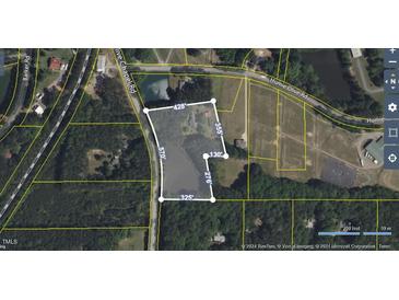 Aerial view of a property with boundaries outlined and surrounding wooded area and pond at 1917 New Hill Olive Chapel Rd, New Hill, NC 27562