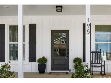 Inviting front door with glass pane and rocking chair on covered porch at 195 N Smith St, Clayton, NC 27520