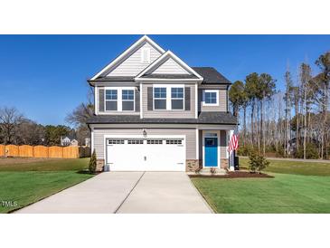 Two-story house with gray siding, white garage door, and blue front door at 22 Van Winkle St, Lillington, NC 27546