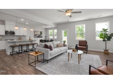 Bright, open living space with modern decor, hardwood floors, and seamless flow to the kitchen at 22 Van Winkle St, Lillington, NC 27546