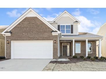 Brick two-story house with a white garage door and landscaping at 36 Steppe Way, Garner, NC 27529