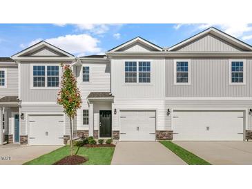 Two-story townhome with gray siding, two-car garage, and landscaping at 168 Perseus St, Angier, NC 27501