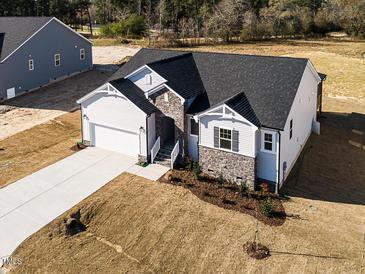 New home features a stone facade, light siding, a two-car garage, and a concrete driveway at 472 Barbour Farm Ln, Four Oaks, NC 27524