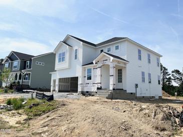 Two-story white home featuring an attached two-car garage and covered porch at 504 Barbour Farm Ln, Four Oaks, NC 27524