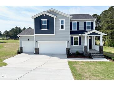 Charming two-story home featuring a three-car garage and manicured lawn, perfect for Gathering living at 576 Barbour Farm Ln, Four Oaks, NC 27524