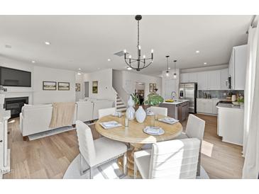 Bright dining area features modern chandelier and seating for six, perfect for Gathering meals at 516 Marthas View Way, Rolesville, NC 27587