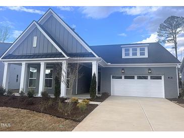 Beautiful one-story home with gray siding, white trim, a two-car garage and manicured landscaping at 208 Regency Ridge Dr, Holly Springs, NC 27540