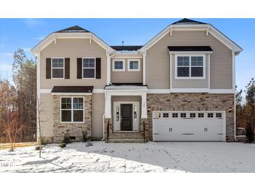 Charming two-story home with stone accents, a two-car garage, and a covered front porch, perfect for curb appeal at 125 Bold Dr, Youngsville, NC 27596