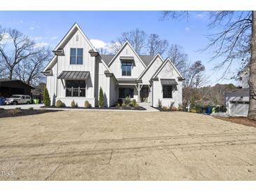 Beautiful modern farmhouse-style home with a manicured lawn and mature trees at 4800 Lakemont Dr, Raleigh, NC 27609