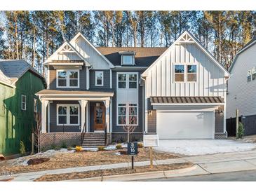 Two-story farmhouse style home with gray siding, white accents, and a three-car garage at 114 Sanderway Dr, Chapel Hill, NC 27516