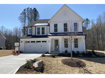 Charming two-story home featuring white siding, black accents, well-manicured landscaping, and a spacious two-car garage at 367 W Amber Oak Dr # 53, Selma, NC 27576