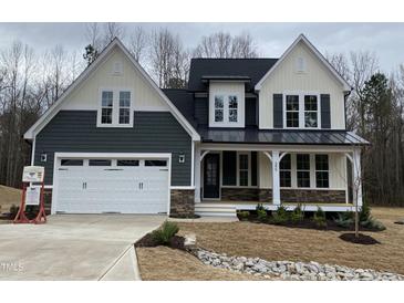 Beautiful two-story home featuring a covered front porch, an attached two-car garage, and manicured landscaping at 399 W Amber Oak Dr # 52, Selma, NC 27576