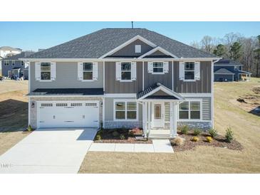 Two-story home with a two-car garage and beautifully landscaped front yard at 135 Newport Lndg, Garner, NC 27529