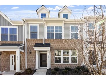 Brick front elevation of charming townhome with gray siding and dormers at 207 Chesapeake Commons Street # 80, Garner, NC 27529