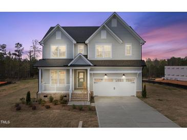 Charming two-story home with gray siding, a two-car garage, and a welcoming front porch at 75 E Star Foal Ln, Wendell, NC 27591
