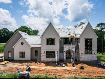 New construction home featuring multiple gables, large windows, and a modern design under a cloudy blue sky at 9105 Overlook Crest Dr, Wake Forest, NC 27587