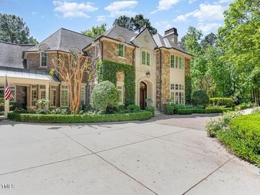 Stone and stucco home with a large driveway and manicured landscaping at 50211 Manly, Chapel Hill, NC 27517