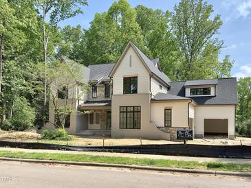Stunning new construction home featuring stone accents, covered porch, and three-car garage at 7208 Tanbark Way, Raleigh, NC 27615