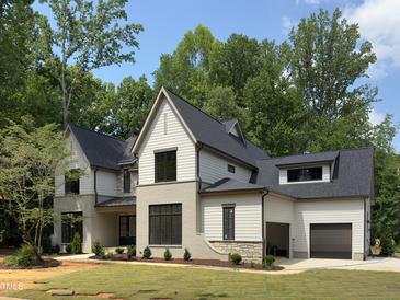 Beautiful two-story home featuring gray brick and siding, with a black roof and well-manicured lawn at 7208 Tanbark Way, Raleigh, NC 27615