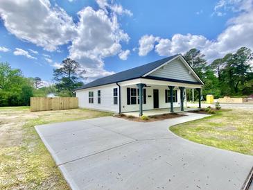 Charming single-story home featuring a concrete driveway, covered front porch, and manicured lawn at 247 Jenkins St, Erwin, NC 28334