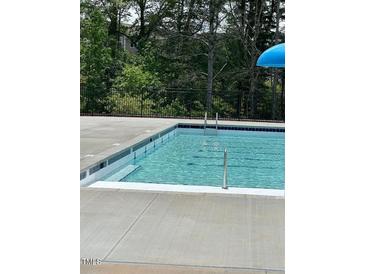 Community pool with easy access, features a light blue interior and is surrounded by a concrete deck at 191 Anise Ln, Garner, NC 27529