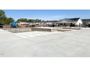 Community pool under construction with an adjacent playground and neighborhood homes in the background at 195 Anise Ln, Garner, NC 27529