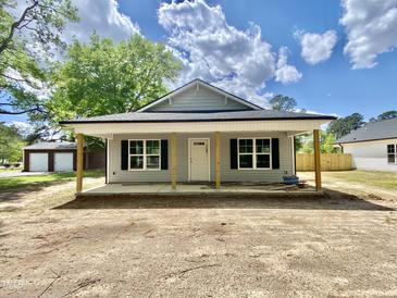 Charming single-story home with a covered front porch, black shutters, and gray siding offers a welcoming facade at 233 Jenkins St, Erwin, NC 28334