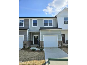 New construction two-story townhome featuring a one car garage and stylish exterior in neutral colors at 1343 Bessie Ct, Wake Forest, NC 27587
