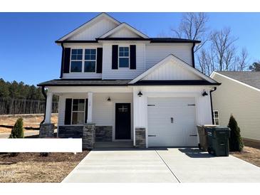 Charming two-story home with a white exterior, black accents, and a well-manicured front lawn at 17 S Mistflower St, Clayton, NC 27520