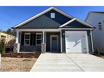 Charming new construction home with a blue exterior, covered porch, and a convenient attached garage at 238 Bluejay St, Clayton, NC 27520
