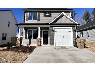 Charming two-story home featuring a two-car garage, stone accents, and manicured landscaping at 24 S Mistflower St, Clayton, NC 27520