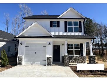 Charming two-story home with a white exterior, black accents, and a well-manicured front yard at 35 S Mistflower St, Clayton, NC 27520