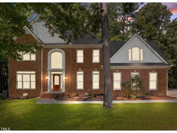 Charming brick two-story home with manicured lawn and elegant arched entryway at 111 N Coslett Ct, Cary, NC 27513