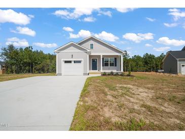 Charming single-story home with neutral siding, attached garage, and freshly poured concrete driveway at 63 Falls River Ct, Broadway, NC 27505
