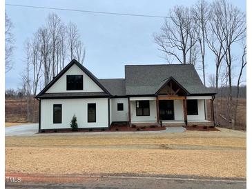 Charming single-Gathering home featuring black trim, a covered porch, and a well-manicured front yard at 2829 Faucette Ln, Burlington, NC 27217