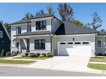 Beautiful two story home featuring professional landscaping, a large garage and grey exterior paint at 123 Cottage Way, Pittsboro, NC 27312