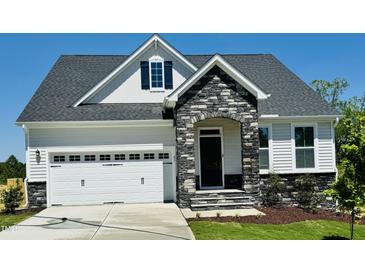 Charming home with a stone-accented entrance, white siding, and a two-car garage at 85 Claude Creek Way, Smithfield, NC 27577