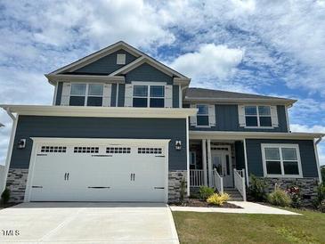 Two-story home featuring a two-car garage and a combination of stone and blue siding at 499 Glenkirk Pl # 101, Garner, NC 27529