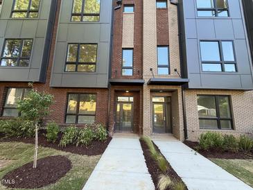 Modern townhome with a brick facade, large windows and manicured landscaping at 704 Chatham View Rd # 12, Cary, NC 27511