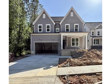 Two-story home featuring gray siding, white trim, a covered porch, and an attached two-car garage at 2613 Silver Gate Ct, Wake Forest, NC 27587
